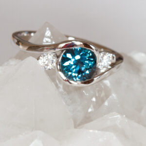 Round teal sapphire and diamond in white gold ring